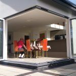 family sits by cornerless bifold doors