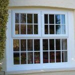 AN ARCHED SASH WINDOW WITH GEORGIAN GLASS IN WHITE UPVC ON A RESIDENTIAL HOME
