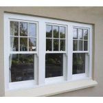 3 PANE UPVC SASH WINDOWS WITH WHITE FRAME ON A CREAM BRICK HOUSE